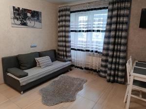 a living room with a couch and a window at Luxuri apartments in Chernihiv
