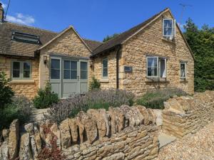 a stone wall in front of a house at 12 Manor Farm Close in Kingham