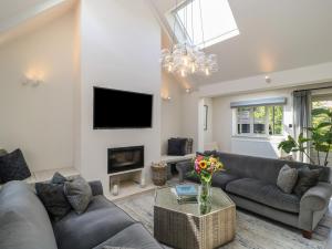 a living room with a couch and a tv at 12 Manor Farm Close in Kingham