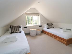 two beds in a attic room with a window at 12 Manor Farm Close in Kingham