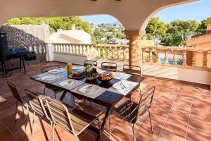 a table and chairs on a patio with a balcony at Villa Nispero in El Tosalet