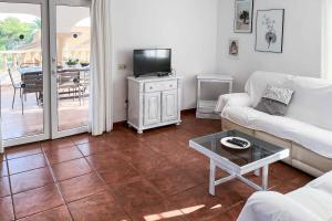 a living room with a couch and a tv and a table at Villa Nispero in El Tosalet