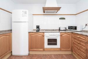 a kitchen with a white refrigerator and a microwave at Villa Nispero in El Tosalet