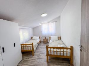a room with two beds and a room with two windows at Muso Apartments in Gevgelija +2 photos
