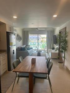 a kitchen and living room with a wooden table and chairs at Blue Coast Condo in Puerto Plata