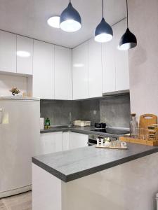 a kitchen with white cabinets and a counter top at Muso Apartments in Gevgelija