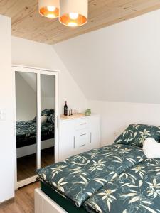 a bedroom with a bed and a mirror at Agroturystyka Nad Lasem - Domki w górach in Toporzysko