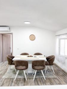 a dining room with a white table and chairs at Muso Apartments in Gevgelija