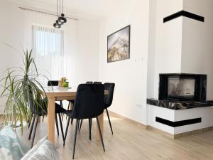 a dining room with a table and a fireplace at Agroturystyka Nad Lasem - Domki w górach in Toporzysko