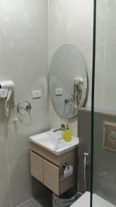 a bathroom with a sink and a mirror at انوار عمان - Anwar Amman Hotel in Amman