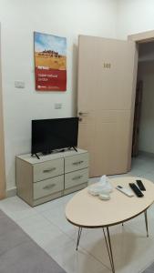 a living room with a tv and a coffee table at انوار عمان - Anwar Amman Hotel in Amman