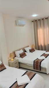 a bedroom with two beds and a window at انوار عمان - Anwar Amman Hotel in Amman