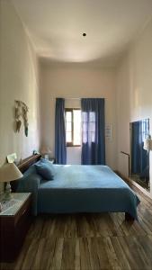 a bedroom with a blue bed and a window at aromasdelpandeazucar in Unquillo