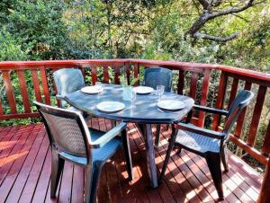 a blue table and chairs on a deck at Forest Edge Hideaway -Six on Imbali in George