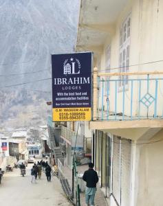a sign on a building with people walking down a street at Ibrahim lodge restaurant in Astor