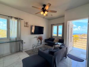a living room with two couches and a ceiling fan at Sea-Renity in Philipsburg