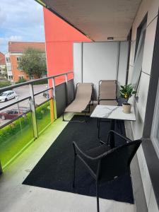 a balcony with two chairs and a table on a building at Modern apartment with large balcony in Halmstad