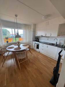 a kitchen and dining room with a table and chairs at Modern apartment with large balcony in Halmstad +1 photo
