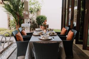 a table with plates and cups on a patio at The Villa - Private Pool near Tanjung Rhu Beach by WOW Holiday Homes in Kuah
