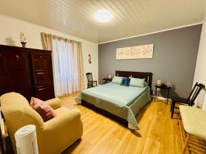 a bedroom with a bed and a couch at Casa das Courelas in Nordeste