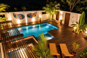 a swimming pool with two chairs and a wooden deck at Casa La Rayanna in Palomino