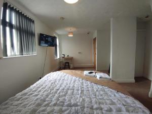 a large white bed in a room with a television at Central Stay Blackpool in Blackpool
