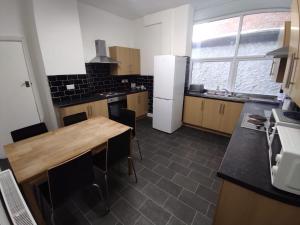 a kitchen with a wooden table and a refrigerator at Central Stay Blackpool in Blackpool