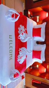 a bed with red and white sheets and red pillows at Chalet Dar Well-Ness in Dar Mohammed Salah