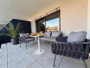 a patio with a couch and a table and chairs at MOOD Apartment Piešťany Centrum, parking, terasa in Piešťany