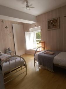 a bedroom with two beds and a window in it at Les Mesanges in Combrand