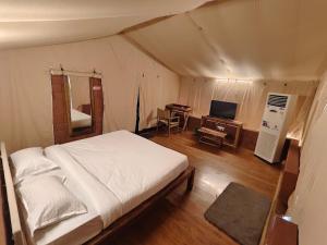 a bedroom with a bed and a desk in a tent at LIVAA NEST Resort Mysore in Kālvādi