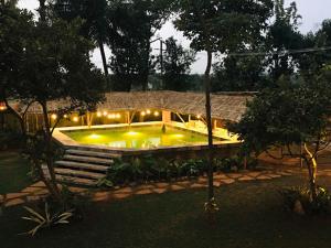a house with a swimming pool with lights in it at LIVAA NEST Resort Mysore in Kālvādi