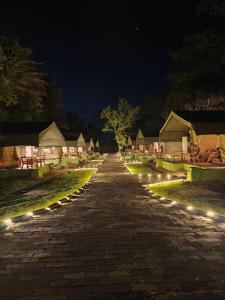 a long brick road with lights at night at LIVAA NEST Resort Mysore in Kālvādi +12 photos