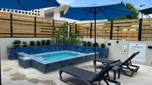 a swimming pool with two chairs and an umbrella at Ocean Breeze in San Juan