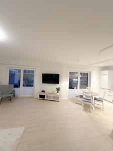 a white living room with a table and chairs at Ferienwohnung Knut in Bornholt