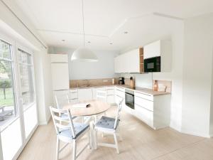 a kitchen with white cabinets and a table and chairs at Ferienwohnung Knut in Bornholt