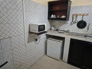 a kitchen with a microwave and a small refrigerator at SEN-HOME Free in Dakar
