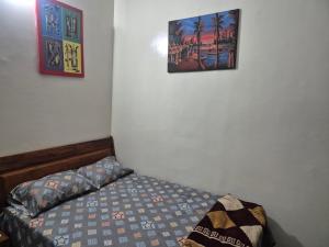 a bedroom with a bed and two pictures on the wall at SEN-HOME Free in Dakar