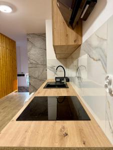 a kitchen with a sink and a counter top at DOBA RENT Wysockiego 104 in Białystok