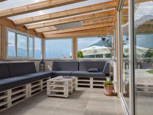 a screened in porch with blue benches and windows at Greiterhof Partschins in Parcines +43 photos