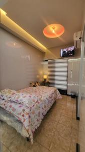 a bedroom with a bed and a tv on the wall at Height 909 Hostal in Juayúa +65 photos