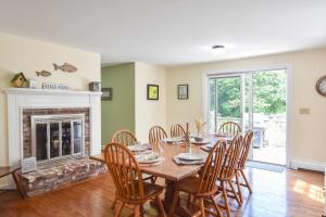 a dining room with a table and chairs and a fireplace at 1 6 mi to Nauset Beach in Orleans +25 photos
