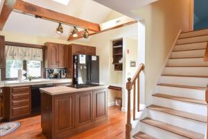 a kitchen with a staircase leading up to a kitchen with wooden cabinets at 1 6 mi to Nauset Beach in Orleans