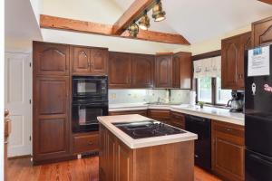 a kitchen with wooden cabinets and a black appliances at 1 6 mi to Nauset Beach in Orleans