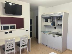 a kitchen with a desk and a tv on a wall at Team Diablo Accommodations in Molinella