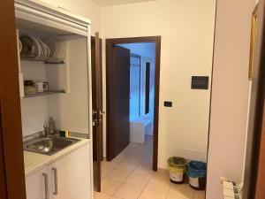 a kitchen with a sink and a door leading into a room at Team Diablo Accommodations in Molinella