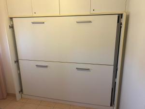 a white cabinet with three doors in a room at Team Diablo Accommodations in Molinella