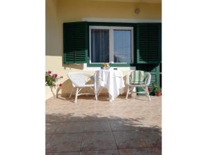 a table and chairs on a patio with a window at Villa Balcsi in Balatonmáriafürdő
