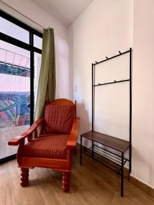 a chair and a table in a room with a window at Chaikoni Lodge in Pucallpa