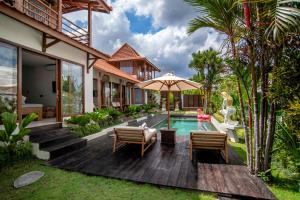 a villa with a swimming pool and a house at Dream Nest Bali in Munggu